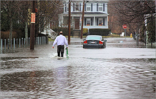A man waded through a flooded street in Quincy on Monday.