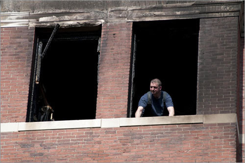 A firefighter looked out from a window after the fire.