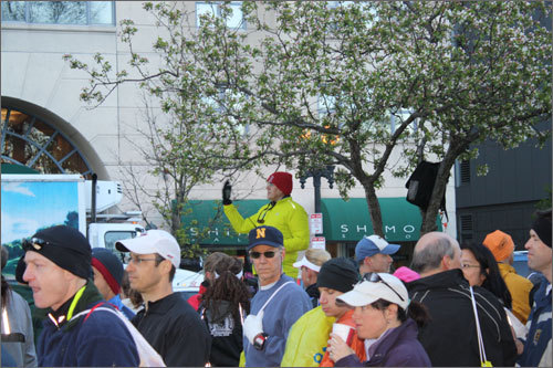 A Marathon volunteer directed buses down Tremont Street as runners awaited to board.