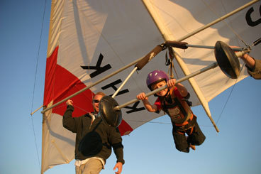 Airborne offspring Until last year, children taking hang-gliding lessons at Kitty Hawk Kites in North Carolina had to weigh at least 80 pounds, which put their age around 12. Now, thanks to new equipment, ‘‘any kid who can understand basic control commands can learn to glide,’’ said marketing director Wes Gutekunst. ‘‘The instructors are holding on to the harness, but the kids are gliding.’’ Callan Lakings, 5, and his sister, Oonagh, 7, of Alexandria, Va., recently experienced that thrill during a three-hour session on the sand dunes of Jockey’s Ridge State Park in Nags Head. ‘‘They really felt like they were flying,’’ said their father, James. ‘‘When you’re only 4 feet tall, suddenly to be 12 or 15 feet off the ground means a lot. They were ecstatic.’’ Milepost 12 on Highway 158 Bypass, Nags Head, N.C., 877-359-8447, www.kittyhawk.com , three-hour classes $99; summer only DIANE DANIEL