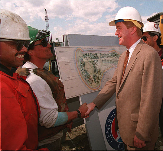 In this 1994 photo, Governor William F. Weld shakes the hand of Scott Wilson, a pier foreman working on the island.