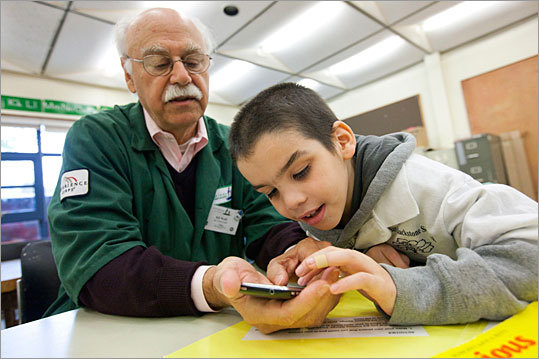 A volunteer with Experience Corps, Bill Wolff, 65, works as a reading coach with second-grader Xavier Weinstein, 7, at Blackstone Elementary School in Boston.