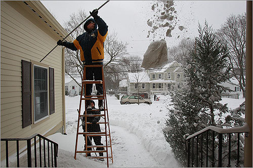 Rick and Ellen Reinhart of Lexington swept snow off of their roof.