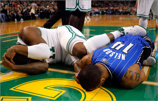 Celtics forward Glen Davis and Orlando Magic point guard Jameer Nelson lie on the floor after colliding and falling hard in the first quarter. Davis left the game but later returned.