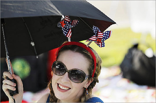Jamie Taker, of Haverhill, wore a headband with American flag-decorated pin wheels before the fireworks display. Spectators gather on Memorial Drive to observe the fireworks in Cambridge.