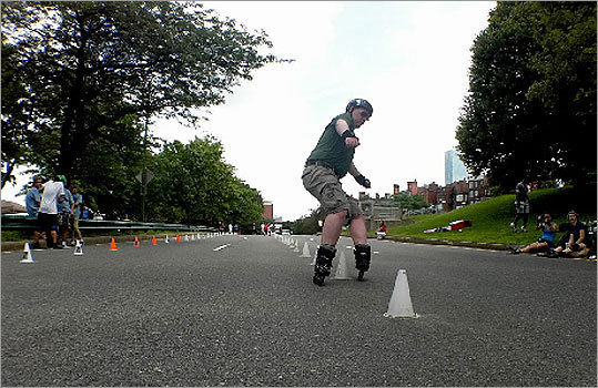 Taking advantage of the closing of Storrow Drive for July 4th festivities, Damon Poole, a past president of the Boston Inline Club, skates through a series of pylons near the Fenway Kenmore exit. A group of skaters gathers each Independence Day for an event called 'Slalom on the 4th.'
