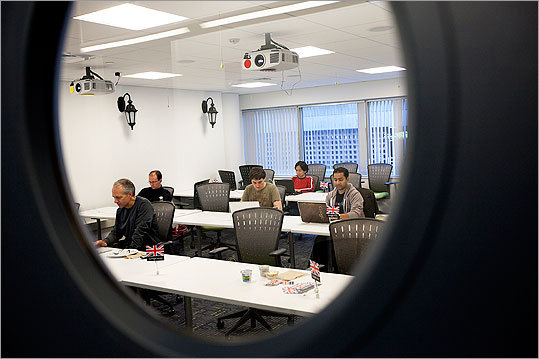Employees sat in a meeting room during a webcast conference.