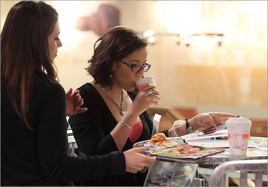 Stefanie Godin (left) and Orquidani Tejada, both of Boston, in the dining area at the Prudential Center market.