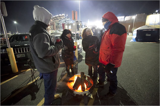 From left, Steve Govoni (cq), of Hingham, Ellen Slawsby-Boudreaux (cq), of Newton, Cori Slade (cq) of Bridgewater, and Brad Yount (cq), of Andover, stand around a fire and tailgate before the game.