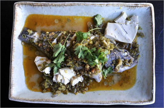 According to tradition, Chef Patricia Yeo steams a black bass with the head and tail intact to symbolize wholeness and a favorable beginning and end to the year.