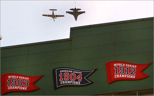 A fighter jet and a mustang plane fly side by side over Fenway Park for its 100-year anniversary.