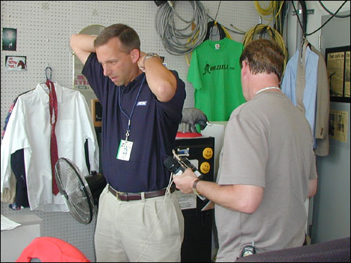 NESN reporter Eric Frede gets wired up in the booth in order to submit a report from the stands at Fenway.