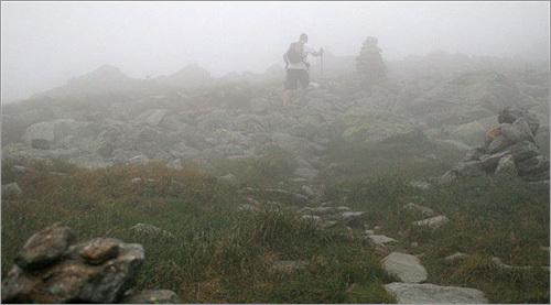 As we headed for the hut, we crossed the Bigelow Lawn, a plateau between Mt. Monroe and Mt. Washington, and I stopped frequently to take in the view and take some photos. We were at an elevation of nearly 5,000 feet, and clouds and mist surrounded us. There wasn't much vegetation, and if you're not paying attention it's not hard to lose the trail among the lichen covered rocks. Cairns, pagoda-like rock piles, dot the trail at this elevation and help guide hikers along the path, acting like high-altitude lighthouses.
