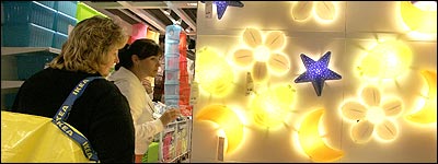 Liane Edwards (left) and Cindy Rebello check out the prices on a wall lamp display at the newly opened IKEA store in Stoughton.