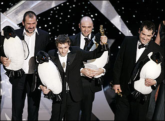 French filmmakers Emmanuel Priou, Yves Darondeau, Christophe Lionel and Luc Jacquet hold their Oscars and stuffed penguins after winning best documentary feature for 'March of the Penguins.'