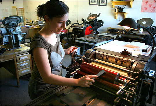 Shelley Barandes, owner of Albertine Press, loads ink onto one of the eight antique letterpress machines she has in her Somerville studio.