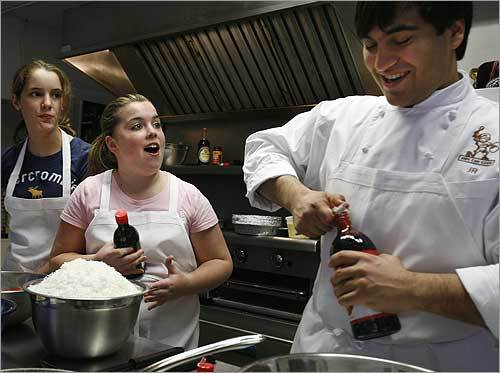 At the Kids Can Cook program at the Paraclete Center in South Boston, executive chef Joshua Riazi (right) jokes with Hallie Cuddahy, 12, next to him, and Sarah Bartel, 12, both of South Boston. The program is tuition-free and offers eight-week after-school cooking and nutrition classes. Many kids will cook for their mothers this Sunday; some help in the kitchen all the time.