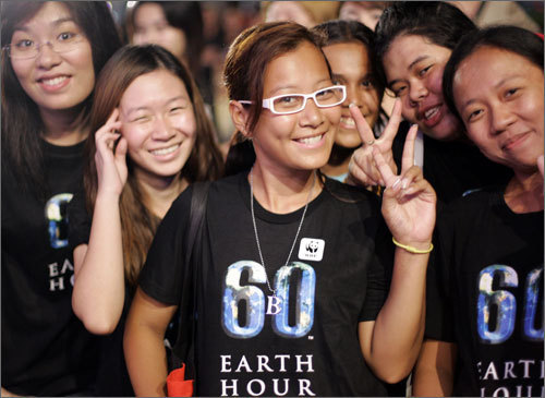 A group of Thais cheered just prior to lights out at Earth Hour ceremonies in downtown Bangkok, Thailand. While all lights in participating cities are unlikely to be cut, it is the symbolic darkening of monuments, businesses and individual homes they are most eagerly anticipating.
