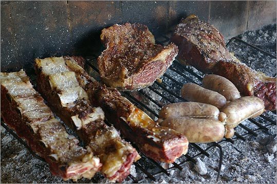 Different meats, cooking at Finca Antonietti near Mendoza, Argentina, come off the grill at different times at an asado.