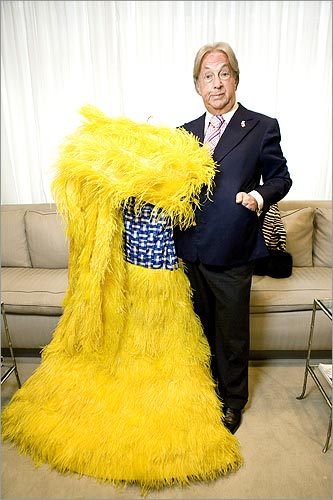 Legendary designer Arnold Scaasi holds a dress made of ostrich feathers.