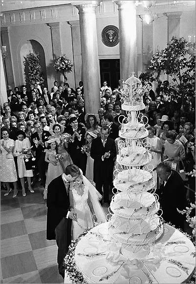 President Richard Nixon applauds as his daughter, Tricia, and her husband, Edward, cut a giant wedding cake at the White House.