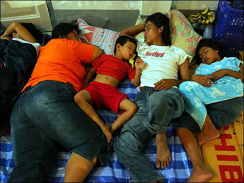 Local residents take shelter from possible aftershocks at city hall in Phuket after the area was hit by a devastating tsunami.