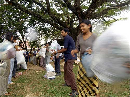 Volunteers form a relay line as they help to transport incoming relief material from vehicles to a makeshift center, which was opened for the general public to donate in the capital of Colombo.