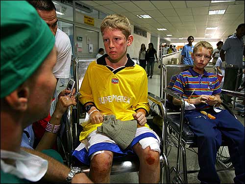 German brothers Marus (L) and Kevin Boehn sit in wheelchairs after being brought to Vachira Phuket Hospital.