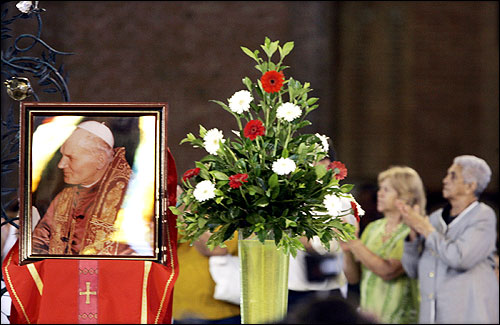Worshippers prayed in front of an image of Pope John Paul II during a Mass in the Our Lady of the Apparition sanctuary in Aparecida do Norte. In Brazil, the world's biggest Catholic country, more than 5,000 people flocked to the Mass.