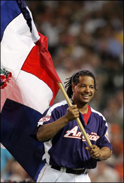 Manny Ramirez, who skipped a media session earlier in the day, waves the Dominican Republic flag to support countryman David Ortiz during Tuesday night's Home Run Derby.