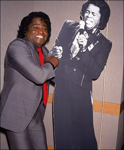 Brown poses next to a cardboard cut-out of himself, in 1991.