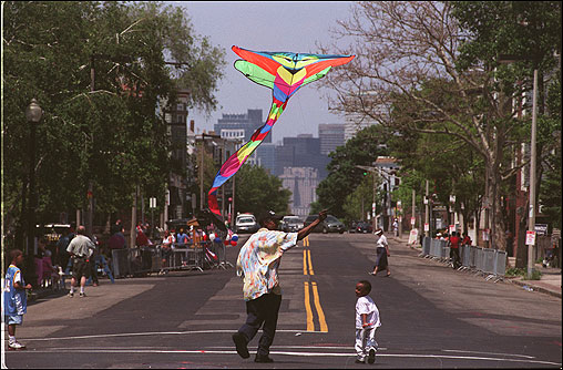 A man and his grandson flew a kite on Dorchester Avenue before the Dorchester Day parade.