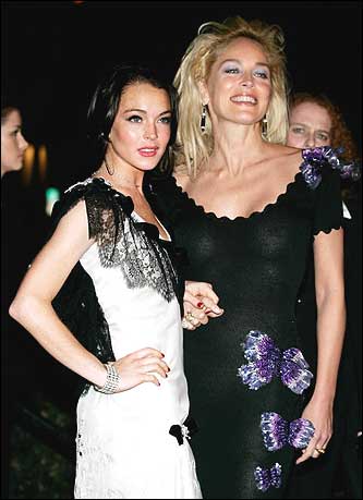Actresses Lindsay Lohan (L) and Sharon Stone pose at the Elton John AIDS Foundation Oscar party.
