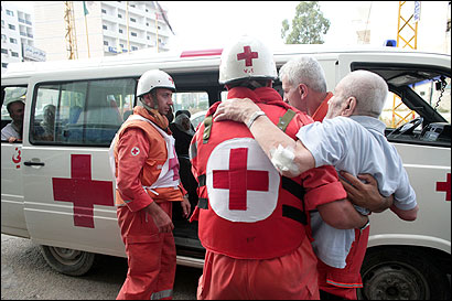 Members of the Lebanese Red Cross carried an elderly resident to evacuate him to Beirut yesterday in Tyre, southern Lebanon. Ambulance drivers have faced perils during the fighting.