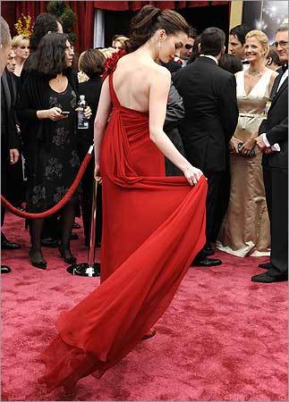 Anne Hathaway adjusts her dress. Anne Hathaway adjusted her dress.