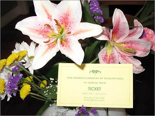 A ticket to the garden tour in a vase full of flowers.