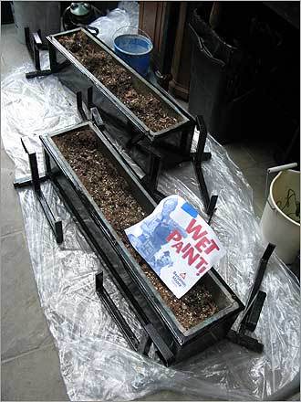 Black window boxes with a 'wet paint' sign on them.