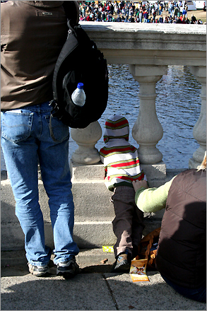 Hoping to get a better peek of the rowers, a young fan looked through the railings on the Anderson Bridge.