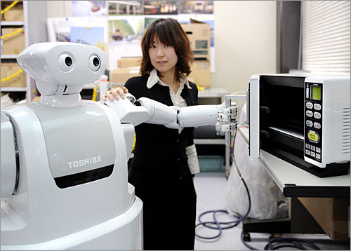 The robot has wired controlled hands with three fingers and small cameras in its palms.