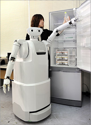 The ApriAttenda robot stands one meter tall and can extend up to a third of a meter higher. Herem It opens the door of a refrigerator and picks up a bottle during a demonstration.