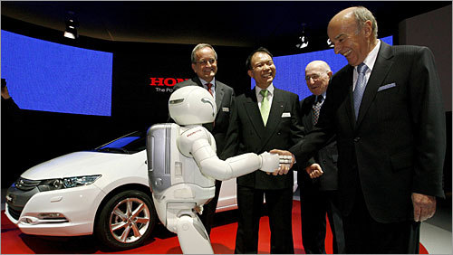 Asimo shakes hands with Swiss president and finance minister Hans-Rudolf Merz at the Geneva Auto Show. The robot stand 4 feet, 3 inches tall and can walk, run, and climb stairs, among other things. Click here for speceifications of the ASIMO robot