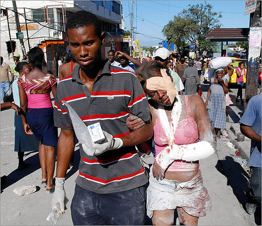 An injured woman was helped after being rescued. Planeloads of rescuers and relief supplies headed to Haiti Wednesday as governments and aid agencies around the world launched a massive relief operation.