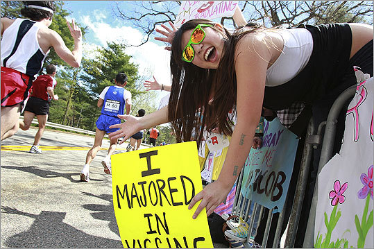 Wellesley College senior Lee Ung held a sign that read, 'I majored in kissing,' as she cheered on marathon runners.