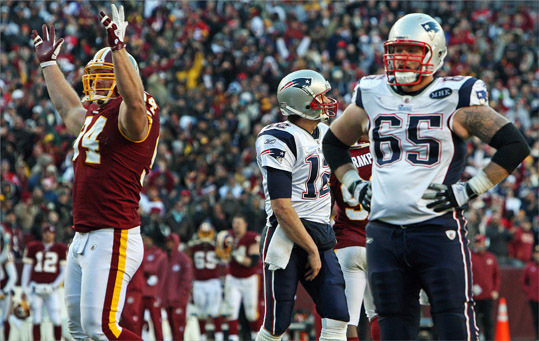 Patriots quarterback Tom Brady (center) and center Nick McDonald (65) reacted, as did Redskins DL Adam Carriker (left) after Brady's pass late in the game was intercepted by Washington's Josh Wilson (not pictured). Brady returned to the bench and engaged in a heated exchange with offensive coordinator Bill O'Brien. After the came, Brady said, ' I deserved it .'
