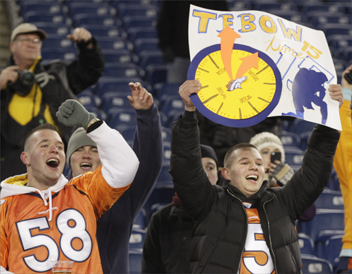 Alex Nedoshitko, left, and Mike Nedoshitko cheer while Denver Broncos quarterback Tim Tebow warms up before an NFL divisional playoff football game between the Denver Broncos and the New England Patriots.