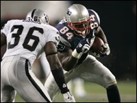Patriots tight end Benjamin Watson after catching a pass from Tom Brady, tried to move past Derrick Gibson of the Oakland Raiders during the 2005 season opener. (Globe Staff Photo/Barry Chin)