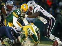 Patriots defensive lineman Ty Warren has his thumb on the nose of Green Bay quarterback Aaron Rodgers (12) as he forces the Packers backup to fumble the ball, which was recovered by New England defender Mike Wright (backround, left). 