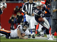 Bears quarterback Rex Grossman (8) tries to bring down Patriots cornerback Assante Samuel (22) after a fourth quarter interception. Artrell Hawkins is at far left.