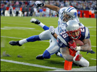 Corey Dillon (28) makes sure he scores as he wraps his arms around the ball (as well as the pylon marking the endzone, which he bends) as he scores the game winning trouchdown.