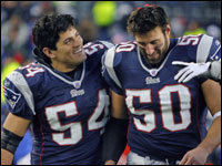 Mike Vrabel (50) who had two interceptions in the game, gets a pat on the head from fellow linebacker Tedy Bruschi (left) after the game.